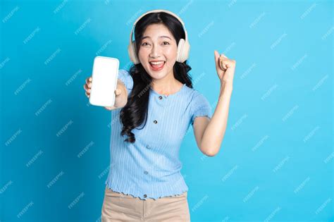 Premium Photo Portrait Of Smiling Asian Woman Posing On Blue Background