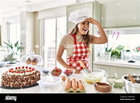 Beautiful Young Brunette Pastry Chef Woman Cooking Pastries At The Kitchen Very Happy And