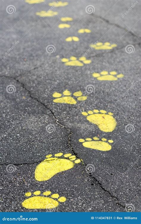 Follow The Colorful Painted Footsteps On Pavement Path Stock Image