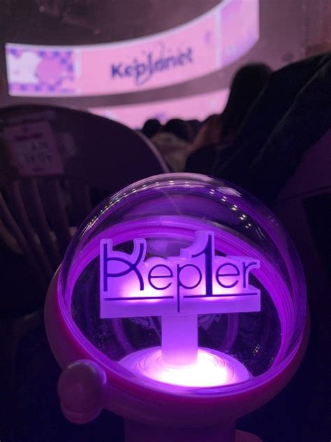 A Lighted Sign That Says Keeper In Front Of An Audience At A Convention