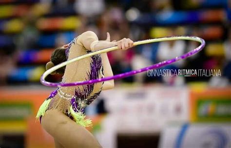 A Woman Is Performing With A Hula Hoop In The Middle Of Her Body And Hands