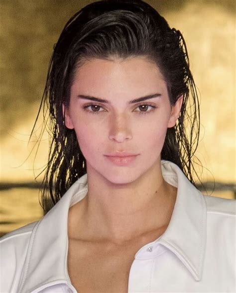 A Close Up Of A Person Wearing A White Shirt And Hair In A Ponytail