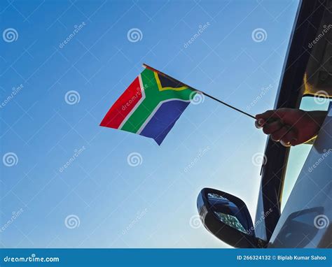 Boy Waving South Africa Flag Against The Blue Sky From The Car Window