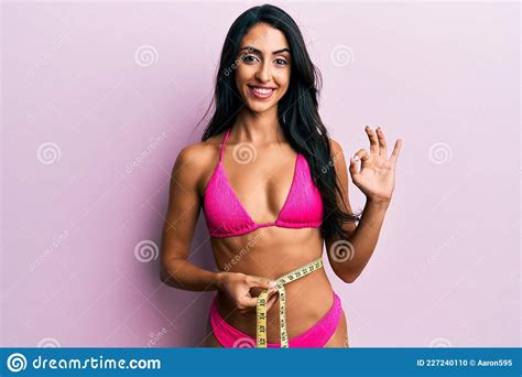 Beautiful Hispanic Woman Wearing Bikini And Measuring Waist Doing Ok