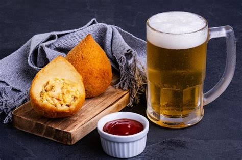 Coxinha frita tradicional rellena de pollo y una jarra de cerveza fría