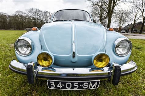 An Old Blue Car Is Parked In The Grass