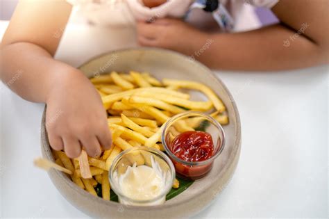 Premium Photo Person Eating French Fries With Ketchup And Mayonnaise