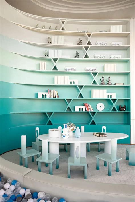 A White Table And Chairs Sitting In Front Of A Book Shelf