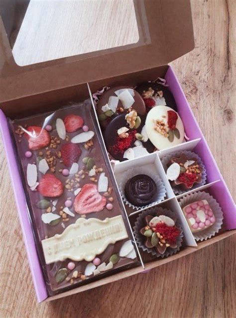 A Box Filled With Assorted Chocolates On Top Of A Wooden Table