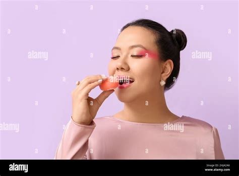 Beautiful Asian Woman Eating Tasty Japanese Mochi On Color Background