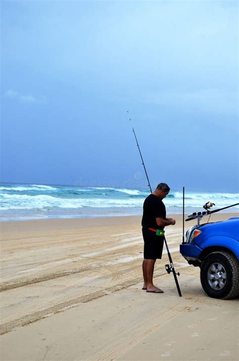 Man Preparing Fishing Rod To Start Fishing On Fraser Island Beach