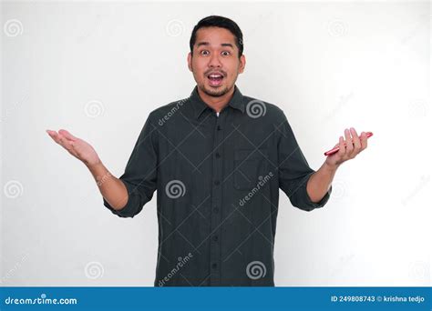 Adult Asian Man Showing Doubtful Gesture While Holding His Mobile Phone