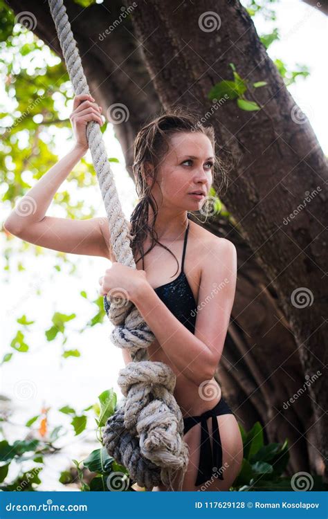 Sensual Woman Swinging In A Patio Wearing A Bikini Near The Beach Stock