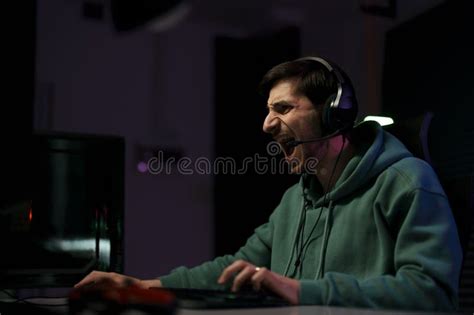 Male Cybersport Gamer Screaming While Playing Video Game Stock Photo