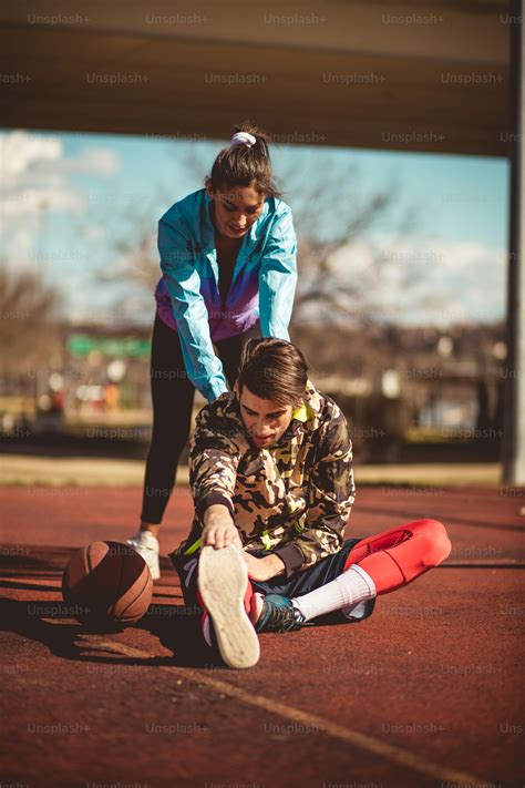 Injuries during the game. Young couple on basketball court. photo