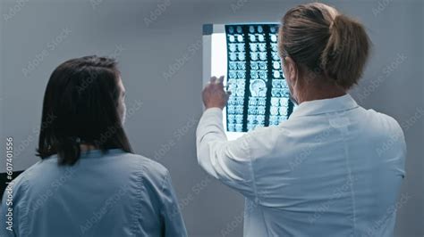 Rear View Shot Of Two Modern Doctors Working Together In Hospital