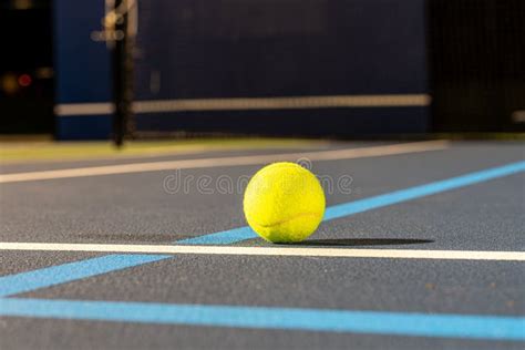 Closeup Of A Tennis Ball At The Intersection Of Blue Tennis Courts With