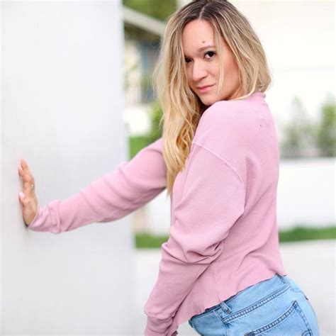 A Woman Leaning Against A Wall With Her Hand On The Side