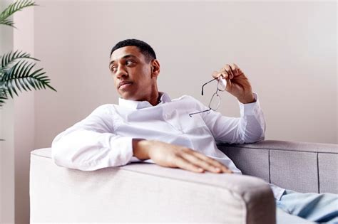 Premium Photo Pensive African American Man In Glasses And Shirt Sits