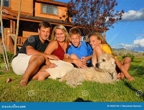 Famille devant la maison image stock Image du mère canin 4029743