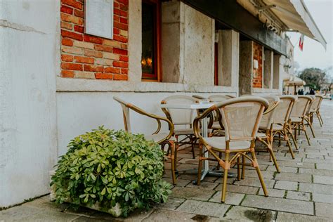 Charming Outdoor Cafe Seating with Brick Wall · Free Stock Photo