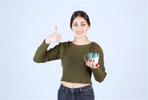 Ein Junges Hübsches Frauenmodell Das Eine Tasse Heißes Getränk Hält Und Sich Einen Daumen Zeigt