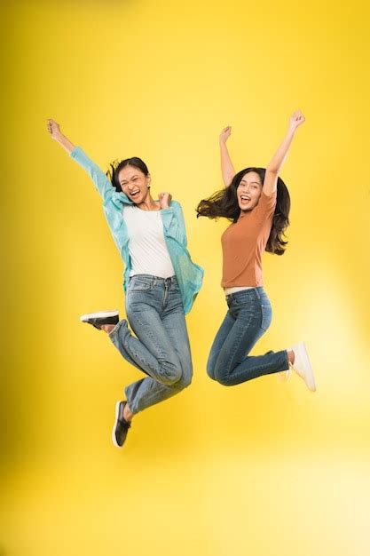 Premium Photo Full Length Of A Young Woman Jumping Over Yellow Background