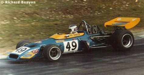 A Blue And Yellow Race Car Driving Down The Road