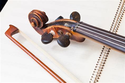 Premium Photo Violin Bow And Scroll On Music Book