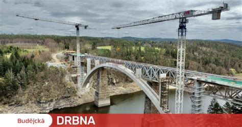 Stavbaři vybetonovali pilíře nad obloukem nového železničního mostu