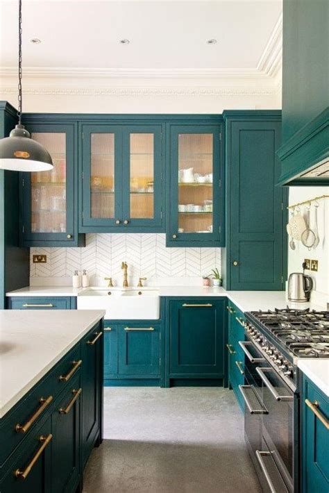 a teal kitchen with glass and usual cabinets, white countertops and a ...