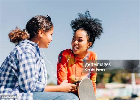 Two Preteen Girls Sharing Earphones Photos And Premium High Res