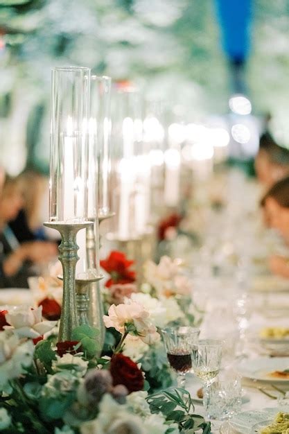 Premium Photo Burning Candles On Candlesticks With Glass Caps Stand On A Festive Table Among