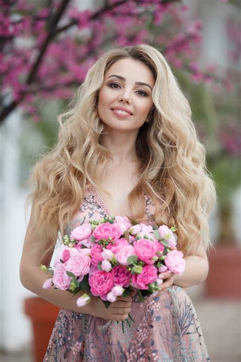 Schitterend Portret Van Een Blondemeisje In Een Avond Sexy Roze Kleding Met Een Boeket Van Mooie