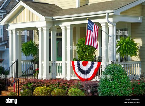 An American Flag And Buntings Hang From A Front Porch Of An Upscale