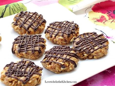 Several Cookies With Chocolate Drizzled On Them Sitting On A White Platter