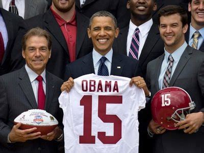 President Obama Holds Up A Football Jersey With His Team Mates