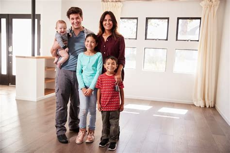 Retrato de familia feliz con bebé estar de pie en vacío salón