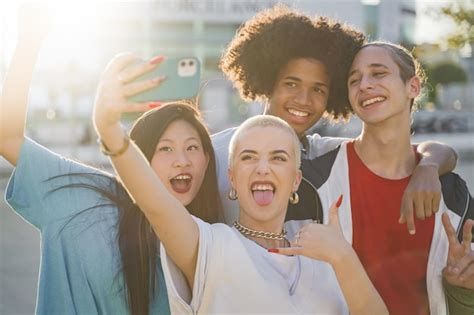 Amigos adolescentes multiétnicas tirando uma foto de grupo selfie e