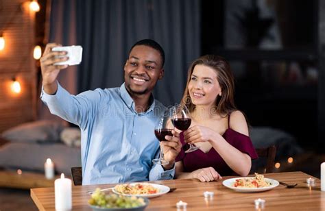 Home Date Happy Interracial Couple Having Dinner And Taking Selfie On Smartphone Stock Image