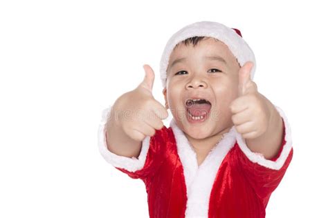 Pouco Menino Do Natal Que Mostra Os Polegares Acima Imagem De Stock