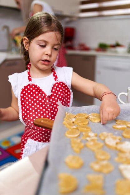 Niña haciendo galletas de jengibre en casa Foto Premium