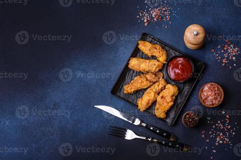 Fried Crispy Chicken Nuggets With Ketchup On Black Plate On A Dark