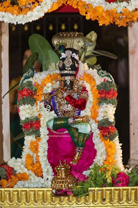 The Statue Is Surrounded By Flowers And Other Decorations