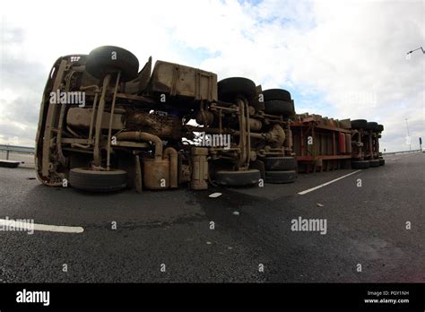 A Lorry Overturns And Spills Its Load Of Recycling Waste Across The