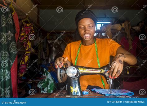 Portrait Of A Pretty Young African Female Tailor Smiling While Working