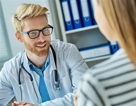 Premium Photo Doctor Blonde Man Talking To Woman Blond Patient In Office Clinic Smiling