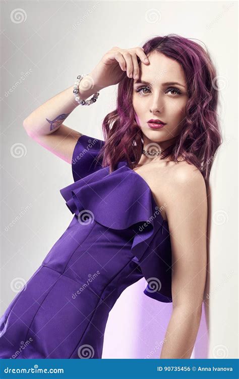 Woman With Purple Hair And A Purple Dress Posing Near The Wall Fashion