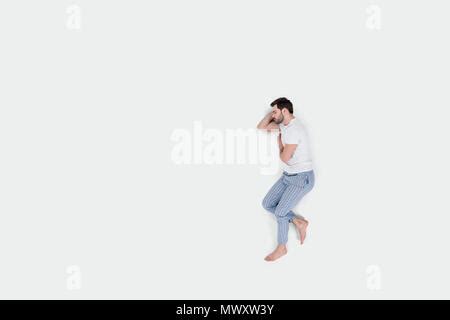 Man In Pajamas Sleeping On Cloud And Floating Isolated On White