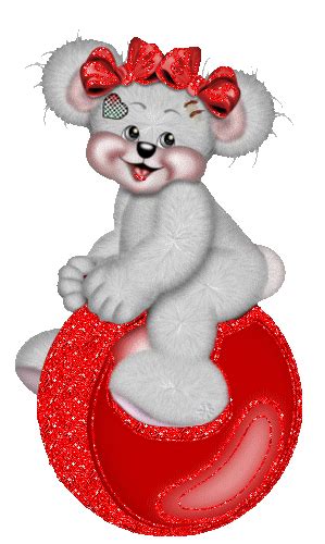 A White Teddy Bear Sitting On Top Of A Red Ball With A Bow In Its Hair